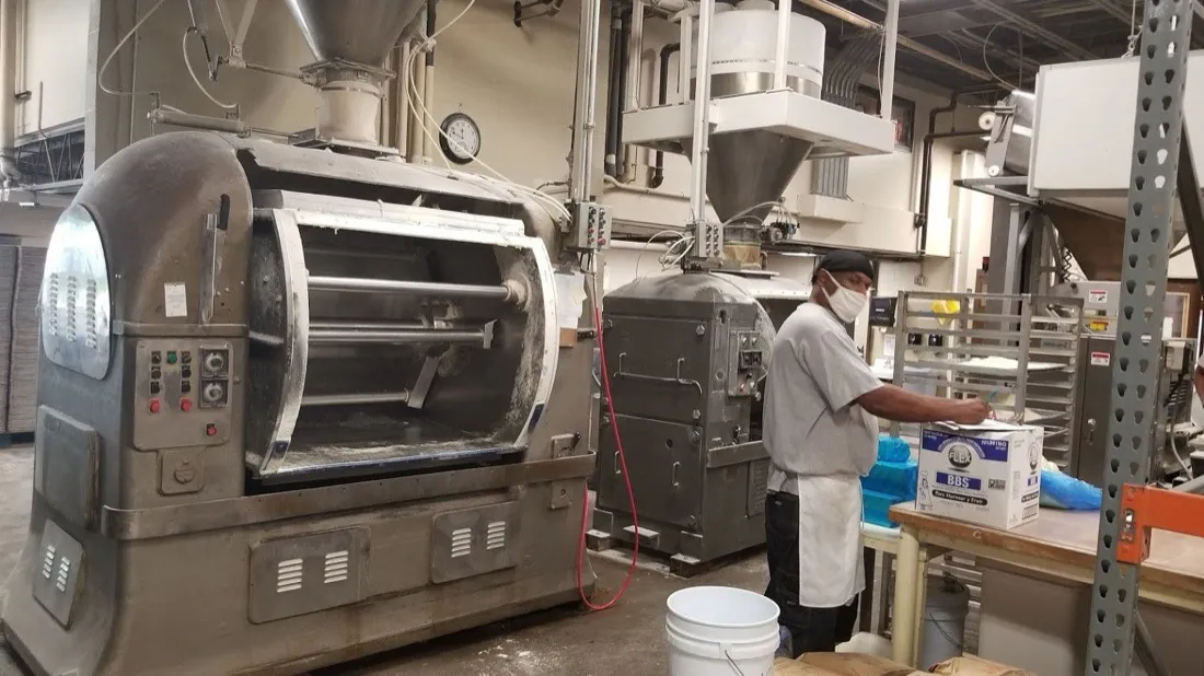 Baker working beside industrial mixers in the Brockton bakery